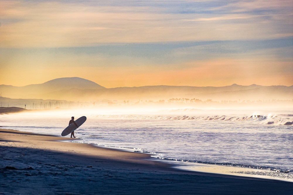 Ultimate 2024 Guide to Living in Coronado | Why You Should Move There 5 shutterstock 1007620036 1 Surfer out on Coronado Beach early in the morning.