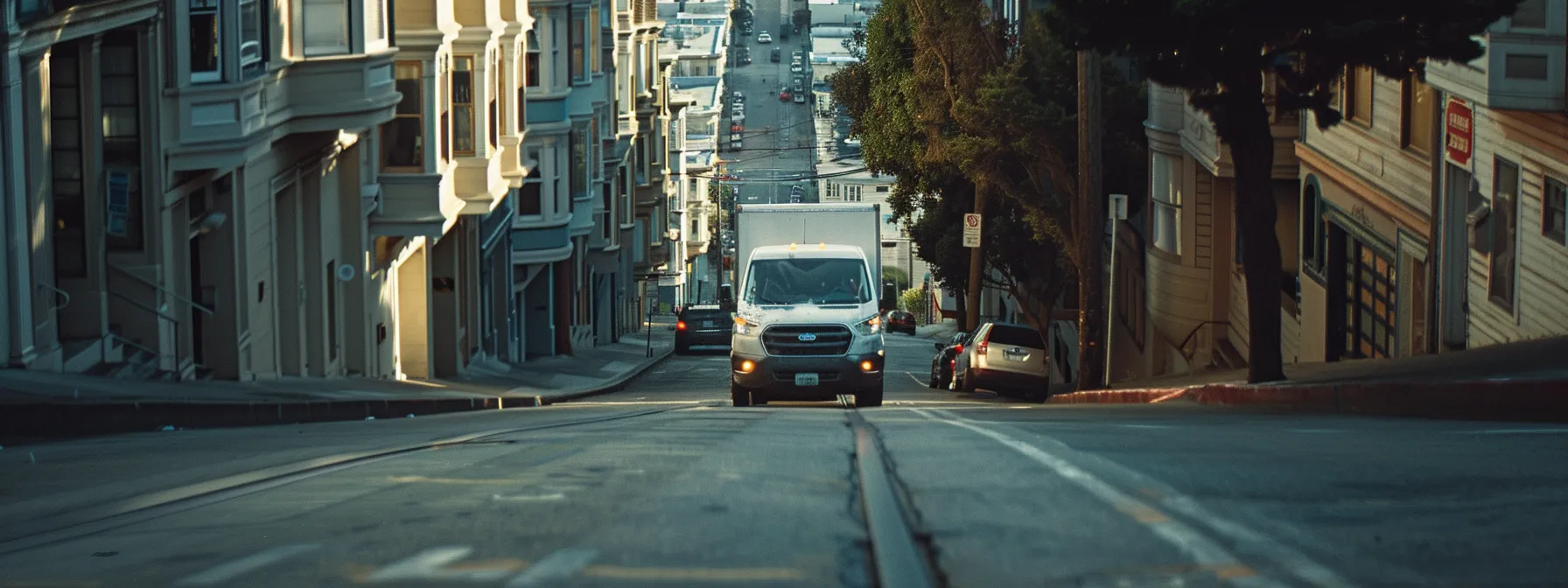 a residential mover carefully navigates a steep hill in san francisco, with narrow streets lined with historic buildings, facing parking constraints and heavy traffic.