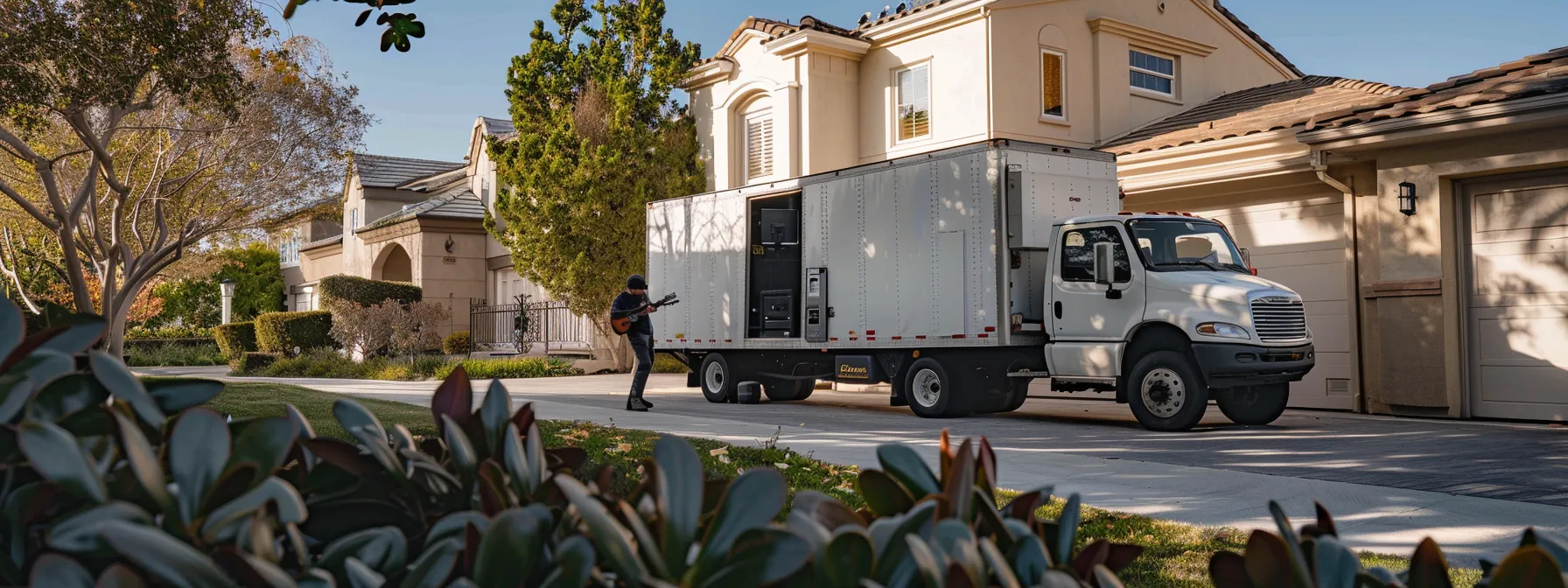 a moving truck parked outside a house in irvine, ca, with a large gun safe being carefully loaded by movers, showcasing a licensed and insured moving company in action. a moving truck parked outside a house in irvine, ca, with a large gun safe being carefully loaded by movers, showcasing a licensed and insured moving company in action.